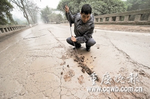 養(yǎng)路工用稀泥敷危橋裂縫排險(圖)