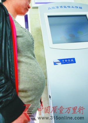 　　王女士在反假貨幣工作站旁。深圳晚報記者 丁開 攝