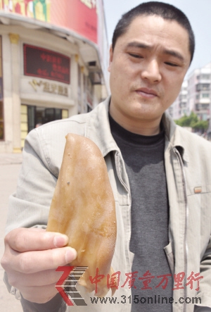 一位市民展示買到的人造豬耳朵 新華社發(fā) 一位市民展示買到的人造豬耳朵 新華社發(fā)