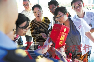 　　近日，工商執(zhí)法人員正在向市民介紹真假國窖1573的辨別方法。賀文兵 攝